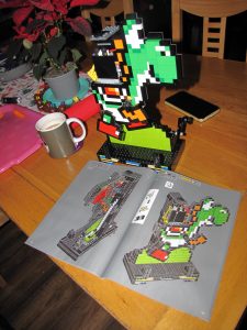 Partially built model of Yoshi with instruction manual.
